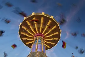 Evening Sky With Clouds Drucke: An illuminated carousel at dusk
