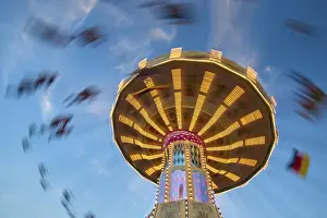 Illuminated Amusement Ride Drucke: An illuminated carousel at dusk