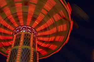 Nighttime Amusement Ride Drucke: An illuminated carousel in motion at night