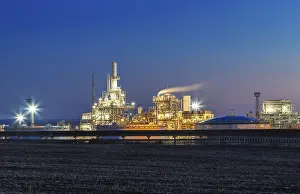 Industrial Building At Night Drucke: Illuminated factory complex at night