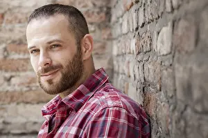 Young Male Model Drucke: An image of a bearded man at the brick wall