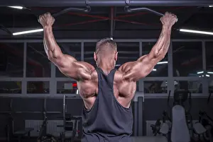 Weightlifting Exercise Drucke: Image of a powerful athlete doing a pull-up in the gym