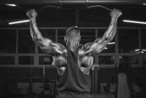Weight Training Routine Drucke: Image of a powerful athlete doing a pull-up in the gym