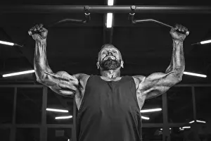 Weight Training Routine Drucke: Image of a powerful athlete doing a pull-up in the gym