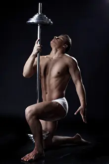 Fitness Studio Shot Drucke: Image of strong young guy posing with rod