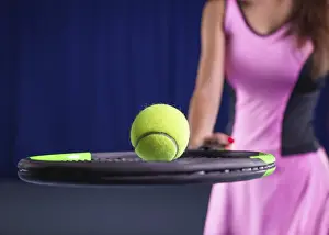 Young Woman Tennis Drucke: Image of a tennis ball on the background of the strings of the racket
