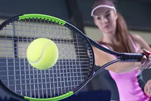 Young Woman Tennis Player Drucke: Image of a tennis ball on the background of the strings of the racket