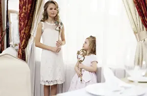 Sisters Looking At Camera Drucke: Image of two young nice sisters posing at camera
