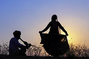 Morning Sunrise Atmosphere Drucke: Indian gypsy dancing in front of setting sun