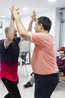 Mental Health Support Drucke: Two individuals engage in a supportive high-five activity