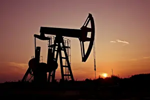 Oil Industry Equipment Drucke: An industrial pumpjack in the sunset