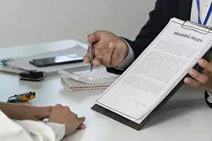 One Person Working Drucke: An insurance agent presenting a policy document to a client