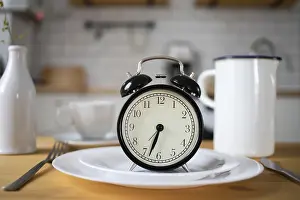 Fitness Exercise Motivation Drucke: Intermittent fasting concept alarm clock on kitchen table