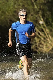 Recreational Activity In Southern Germany Drucke: Jogger running through a stream