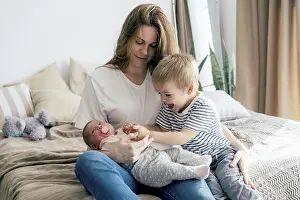 Family Moments Drucke: Junge Mutter mit Kindern zu Hause