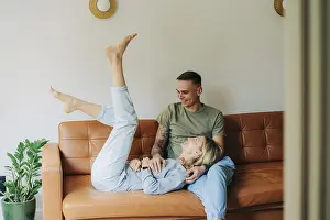 Caucasian Couple On Sofa Drucke: Junger kaukasischer Mann