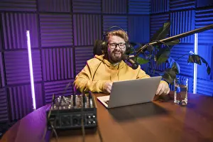 Bilder Datiert 6. Februar 2024: Print smiling male radio host reading microphone