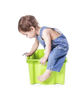 Isolated Studio Shots Drucke: Kid plays with plastic container isolated on white