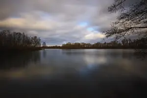 Long Exposure Water Photography Drucke: Lake with trees and a cloudy sky