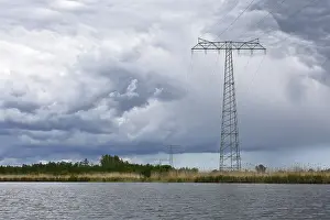 Northern German Scenery Drucke: Landscape with high power pole under dramatic waterside cloud formations