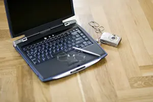 Home Office Work Space Drucke: Laptop and digital camera on the floor