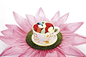 Food Still Life Studio Shot Drucke: Large paper flower and easter cup filled with candy easter eggs