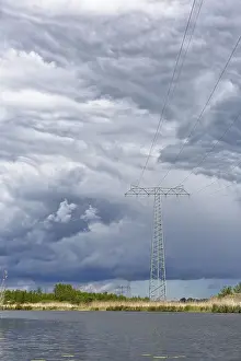 Nature Park Peenetal Drucke: A large power pole in a vast landscape under dramatic clouds