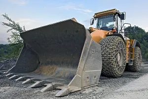 Construction Equipment Drucke: Large wheel loader with tire chains in a quarry