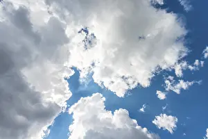 Low Angle Cloud View Drucke: Large white clouds against a blue sky