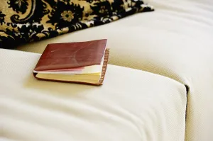 Time Management Tools Drucke: A leather-bound notebook lying on a sofa