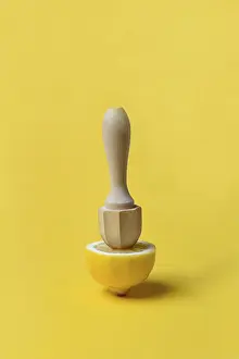 Yellow Background Image Drucke: Lemon and lemon squeezer against a yellow background