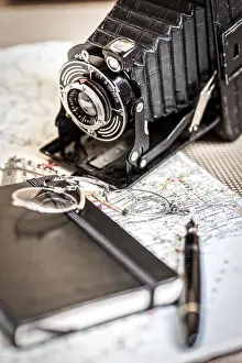 Old Photography Equipment Drucke: Still life with an old camera, pen
