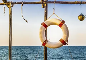 European Countryside Scenery Drucke: Lifesaver hanging on a basic wooden structure on the coast