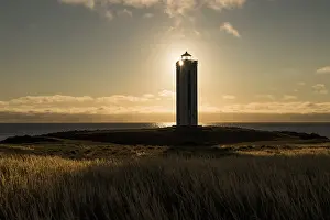 Atmospheric Coastal Scene Drucke: Lighthouse in the backlight, Kalfshamarsvik