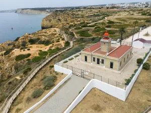 Algarve Lighthouse Drucke: A lighthouse on the coast, surrounded by cliffs