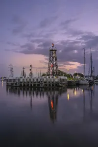 Evening Atmosphere In The Netherlands Drucke: Lighthouse in the harbour at blue hour