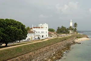 Deserted Asian Beaches Drucke: Lighthouse on the seafront with a long wall