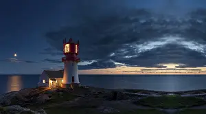 Coastal Region Photography Drucke: Lighthouse surrounded by rocks at night