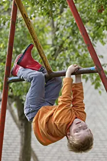 Daytime Leisure Activities Drucke: Little boy playing on monkey bars