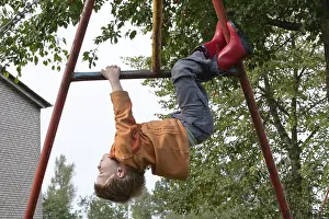 Daytime Leisure Activity Drucke: Little boy playing on monkey bars