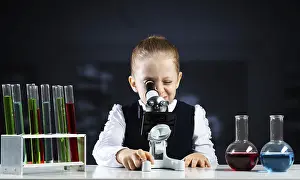 Little Scientist Drucke: Little scientist looking through microscope in classroom