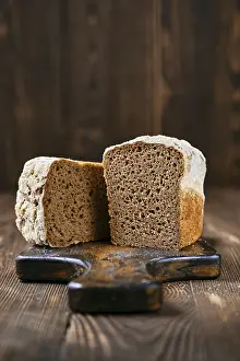 Black Table Setup Drucke: Loaf of artisan rye bread cut on half