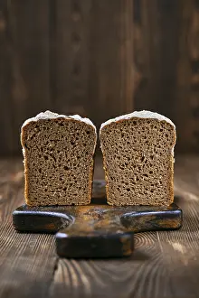Black Table Setup Drucke: Loaf of artisan rye bread cut on half