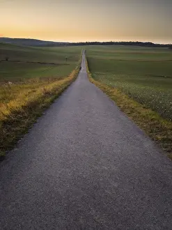 Evening Sunshine Landscape Drucke: Lone road into the sunset sky