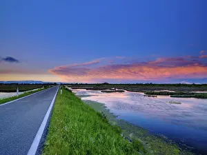 Dramatic Clouds Europe Drucke: Lonely road and dramatic clouds over the lagoon of Venice