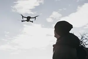 Remote Controlled Aircrafts Drucke: Low angle man watching drone