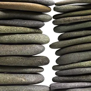 Deserted Beach Landscape Drucke: Low angle view of two flat pebble stone stacks in light back