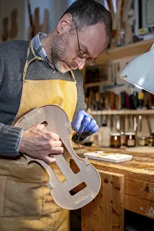 Bilder Datiert 3. Dezember 2024: Luthier restauriert ein Geige in einem Werkstatt.