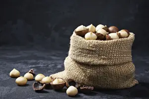 Black Table Setup Drucke: Macadamia nuts in a bag on a black table