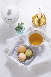 White Table Setting Drucke: Macarons dessert and cup of tea on white table